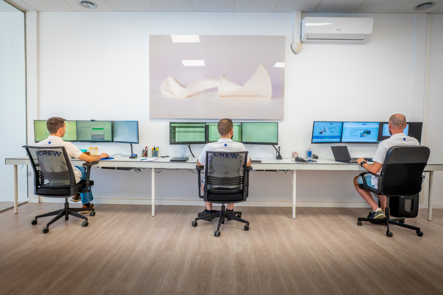 Técnicos de sistemas trabajando y monitorizando equipos en la oficina